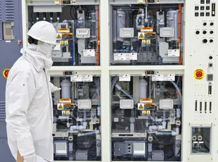 Technician in cleanroom gear at process equipment