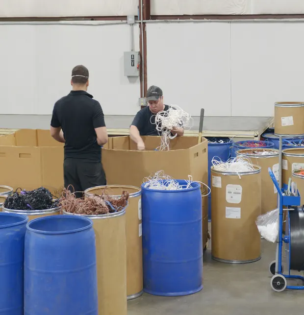 FRL team members sorting reprocessed fluoropolymer materials into drums